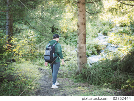 A man with backpack walks in the  autumn forest. 82862444