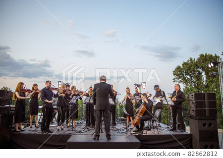 Musical ensemble playing classic instrumental music on the street Musical ensemble playing classic instrumental music on the street 82862812