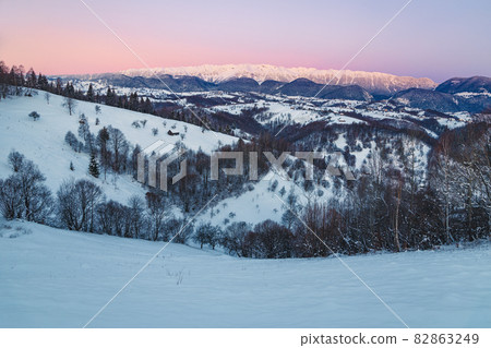 Amazing winter snowy landscape with mountains at sunrise, Carpathians, Romania 82863249