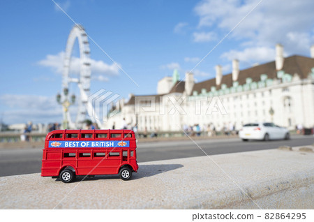 London, U.K., July 22,2021 - miniature red bus on London Eye background, hystorical construction in London, tourist atraction. London, U.K., July 22,2021 - miniature red bus on London Eye background, hystorical construction in London, tourist atraction. 82864295