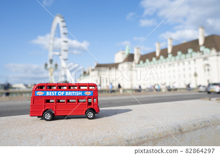 London, U.K., July 22,2021 - miniature red bus on London Eye background, hystorical construction in London, tourist atraction. 82864297