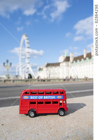 London, U.K., July 22,2021 - miniature red bus on London Eye background, hystorical construction in London, tourist atraction. London, U.K., July 22,2021 - miniature red bus on London Eye background, hystorical construction in London, tourist atraction. 82864298