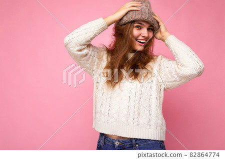 Attractive smiling happy young brunet woman standing isolated over colorful background wall wearing Attractive smiling happy young brunet woman standing isolated over colorful background wall wearing 82864774