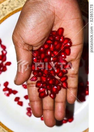 tasty and healthy Pomegranate seeds on hand 82865178