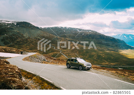 Aurlandsfjellet, Norway. Car SUV Parked Near Aurlandsfjellet Scenic Route Road In Summer Norwegian Landscape. Natural Norwegian Landmark And Popular Destination 82865501