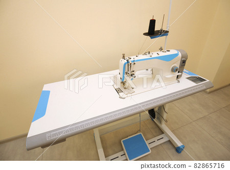 At the workshop. Electric sewing machine placed on a work table 82865716