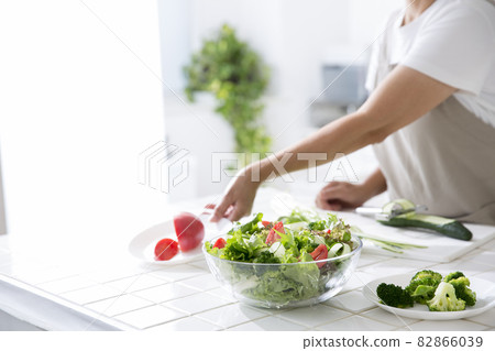 Housewife in the kitchen making salad 82866039