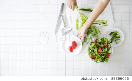 A bird's-eye view, a housewife in the kitchen making salads 82866056