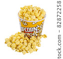 Tasty popcorn with caramel falling into cups on white background 82872258