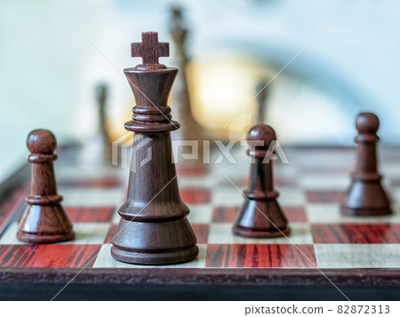 Chess pieces are standing on the board. Black chess king. Close-up. 82872313
