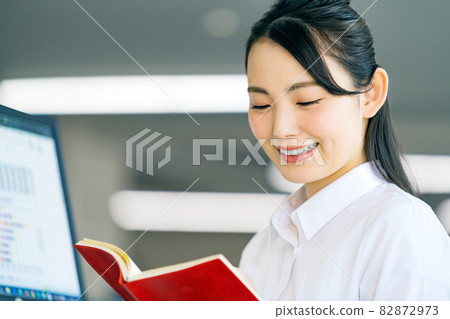 在辦公室檢查筆記本的年輕女商人 82872973