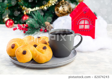Swedish and scandinavian saffron buns Lussekatter with cup of coffee, Christmas decoration Swedish and scandinavian saffron buns Lussekatter with cup of coffee, Christmas decoration 82874243