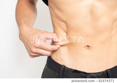 Belly of a man standing in front of a white background Belly of a man standing in front of a white background 82874371