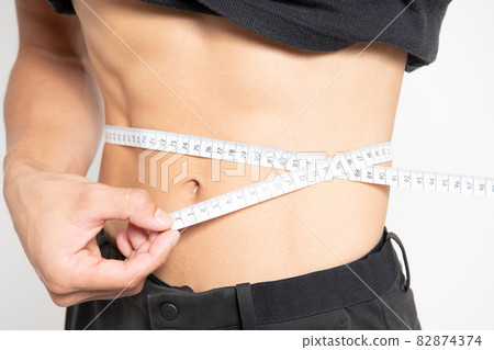 Belly of a man standing in front of a white background Belly of a man standing in front of a white background 82874374