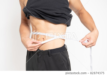 Belly of a man standing in front of a white background 82874375