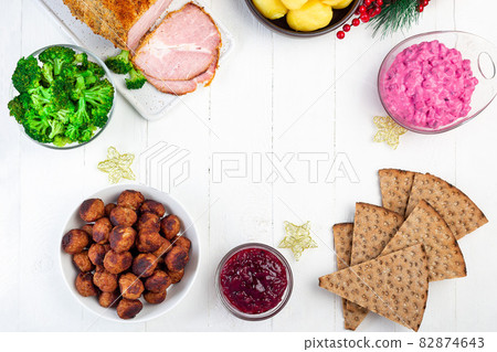 Christmas table with baked ham, beet salad, whole grane crackers, meatballs with lingonberry jam 82874643