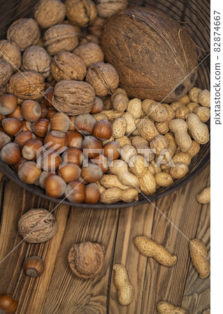 still life with hazelnut peanuts walnut and coconut on wooden board 82874667