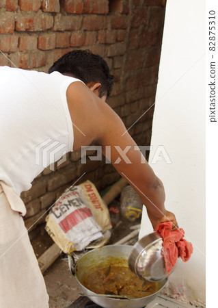 A man cooking curry at home in India 82875310