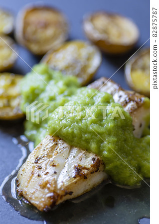 frilled cod fish with green asparagus pea sauce and fried potatoes 82875787