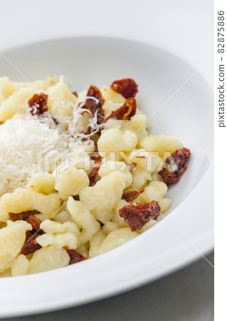 potato dumplings called halusky with dry tomatoes and grated cheese 82875886