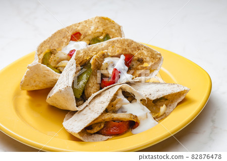 wholewheat  pitta bread filled with grilled chicken meat, jalapenos and red pepper 82876478