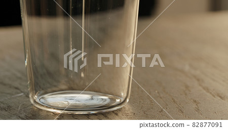 empty tumbler glass on black oak table 82877091