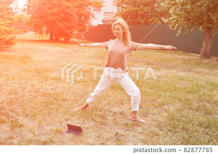 Woman at backyard. Online yoga school. Active vacation. Blonde hair. People Woman at backyard. Online yoga school. Active vacation. Blonde hair. People 82877785