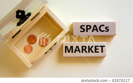 SPACs market symbol. Wooden blocks with words 'SPACs, special purpose acquisition companies market' on beautiful white background, copy space. Chest with coins. Business and SPACs market concept. 82878227