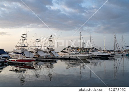 Many motorboats and sailboats Docked at a Marina on dramatic sunrise background 82878962