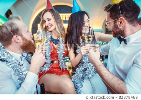 Happy couple and friends clinking champagne flute in bar Happy couple and friends clinking champagne flute in bar 82879469