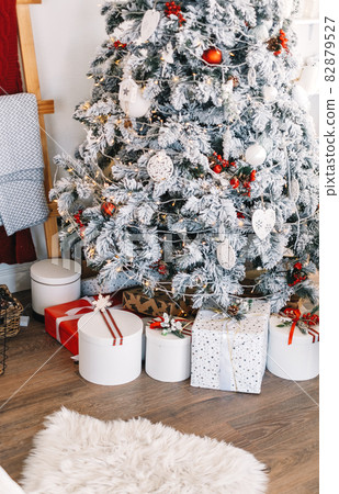 Beautiful Christmas tree with gift boxes in bright white living room. Beautiful Christmas tree with gift boxes in bright white living room. 82879527