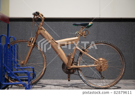 The bike on the street is painted gold. The bike on the street is painted gold. 82879611
