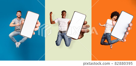 Satisfied happy excited diverse people jumping, have fun and show smartphone with blank screen 82880395