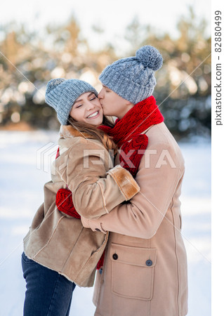 Closeup of loving man kissing his smiling girlfriend, winter shot Closeup of loving man kissing his smiling girlfriend, winter shot 82880499