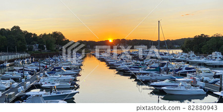 Sunset over a marina full of docked boats 82880943