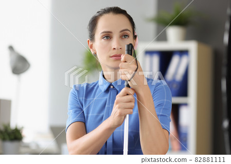 Blind woman with absent gaze looks into the distance and holds stick Blind woman with absent gaze looks into the distance and holds stick 82881111