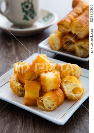 Youtiao.  Long golden brown deep fried dough strip. 82883366