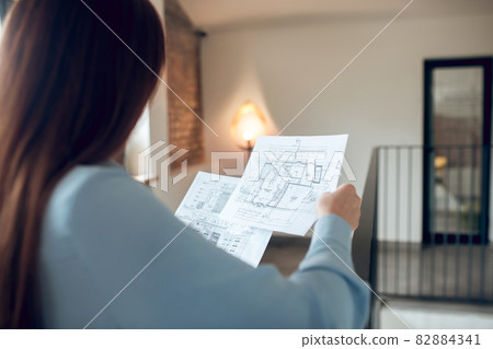 Woman with back to camera studying schemes Woman with back to camera studying schemes 82884341