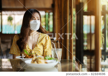 woman with a face mask in restaurant woman with a face mask in restaurant 82884696