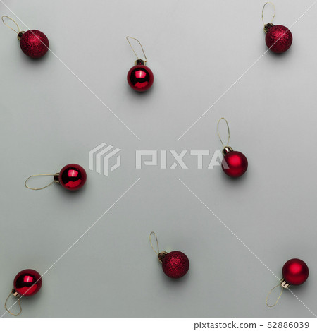 Pattern on gray background with small red Christmas balls or sphere toys for fir tree. Concept for festive minimalistic greeting card or invitation for Christmas eve celebration. High quality photo Pattern on gray background with small red Christmas balls or sphere toys for fir tree. Concept for festive minimalistic greeting card or invitation for Christmas eve celebration. High quality photo 82886039