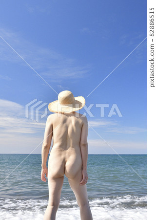 Shooting nude women in straw hats on the summer beach Shooting nude women in straw hats on the summer beach 82886515