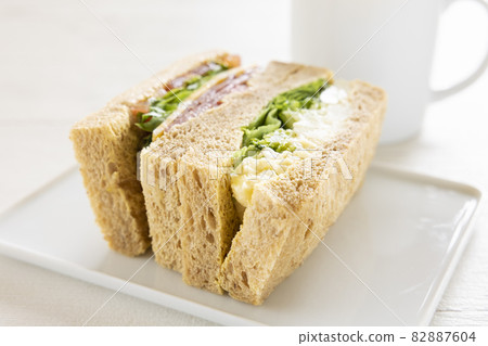 Delicious breakfast pastrami beef sandwich, cheese potato sandwich and hot coffee 82887604