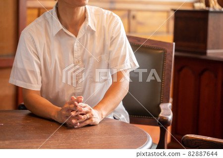 A man who talks with his hands together A person who sits in a chair and talks 82887644