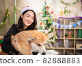 young asian attractive female woman wearing red hat and  playing with her dog  at office weekend holiday activity christmas festival concept 82888883