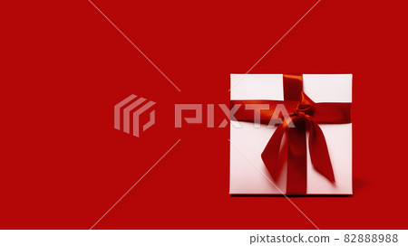 One white gift box with reb bow on red background One white gift box with reb bow on red background 82888988
