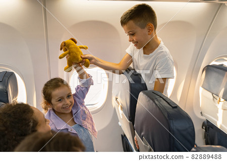 Cute kids playing on board the plane near the window 82889488