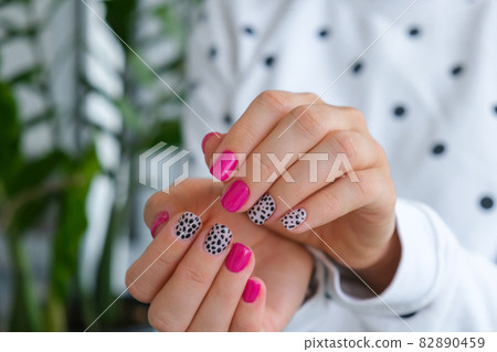 Manicured female hands with stylish pink nails and design. Trendy modern design manicure. Gel nails. Skin care. Beauty treatment. Nail care. Trendy colors Manicured female hands with stylish pink nails and design. Trendy modern design manicure. Gel nails. Skin care. Beauty treatment. Nail care. Trendy colors 82890459