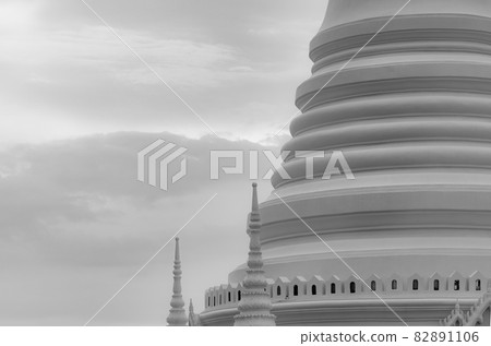 Closeup white pagoda in Thai temple. Classical architecture. Attraction art and ancient architecture in Thailand. Buddhist temple with white sky and gray cloud. Religion architecture. Peaceful concept 82891106