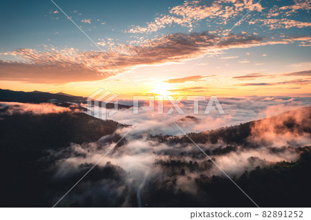 The sun rises in the mist and mountains in the morning The sun rises in the mist and mountains in the morning 82891252