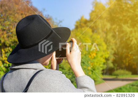 Woman tourist in hat, backpack taking photo. 82891320